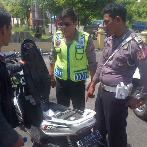 Petugas Kepolisian saat memeriksa motor korban SI (ctr)