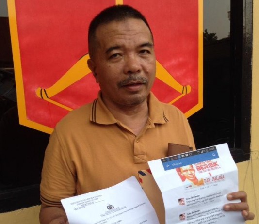 Rusli Jabba saat menunjukan laporan polisi dan screenshot komentar fitnah IS di forum PDKT (hfa)